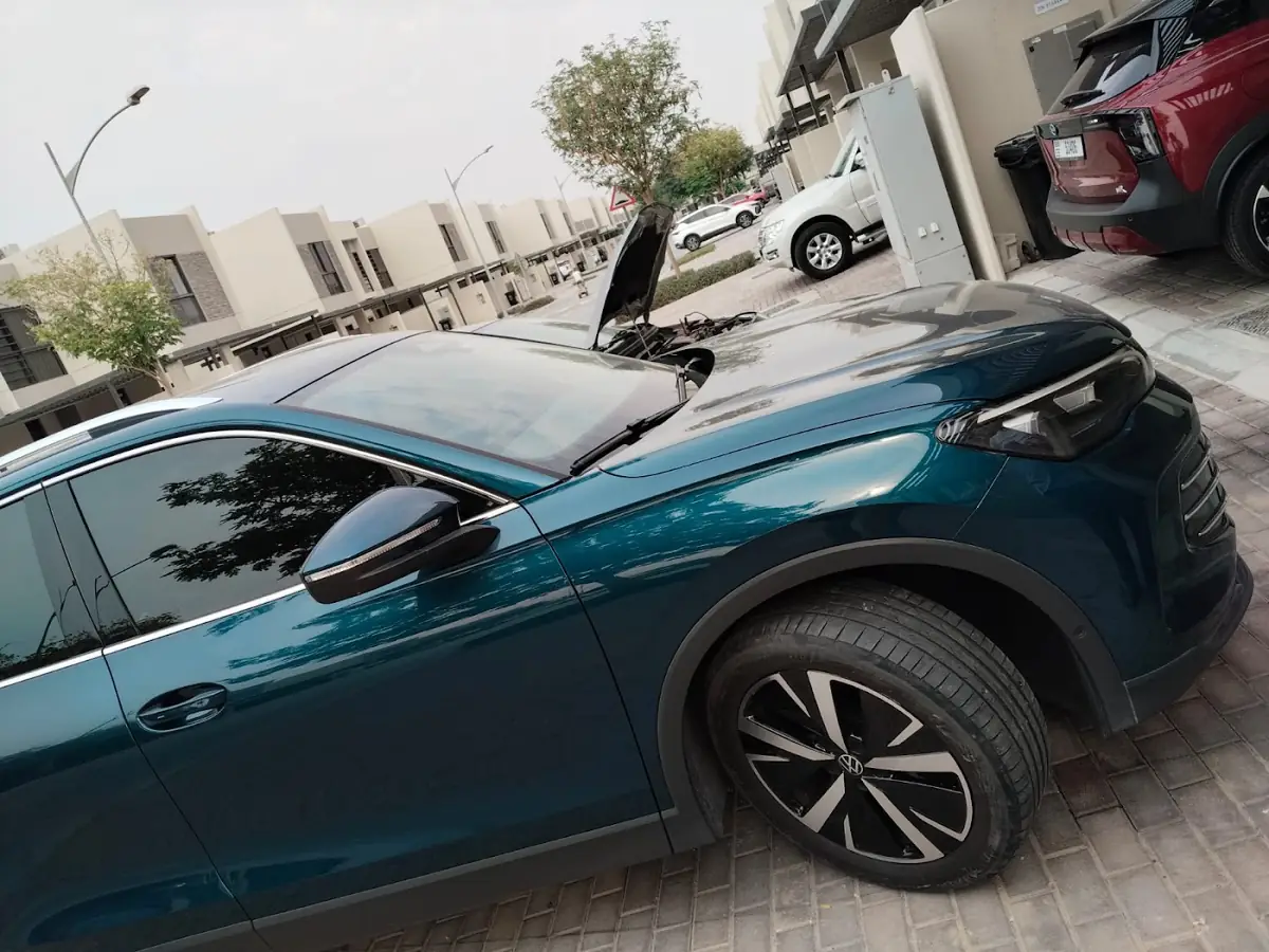 Teal car with a wheel off during a tyre change